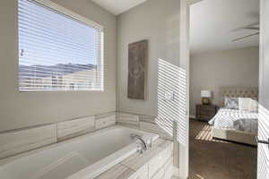 Bathroom featuring tiled bath and a textured ceiling