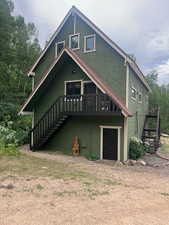 Rear view of property with stairs and a wooden deck