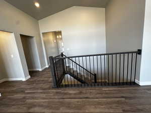 Stairway featuring dark hardwood / wood-style floors and vaulted ceiling