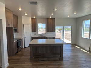 Kitchen featuring sink, dark hardwood / wood-style floors, stainless steel appliances, and a textured ceiling