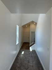 Interior space featuring lofted ceiling and dark colored carpet