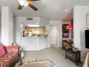 Carpeted living room with ceiling fan