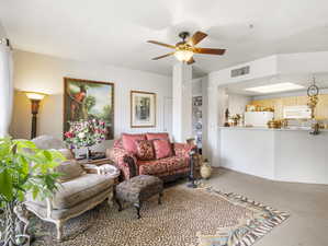 Carpeted living room featuring ceiling fan