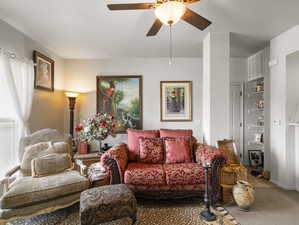 Living room with carpet floors and ceiling fan