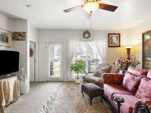 Living room featuring carpet floors and ceiling fan