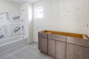 Bathroom with a washtub and a textured ceiling