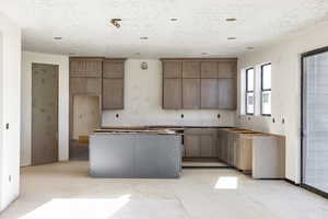 Kitchen featuring a textured ceiling and a center island