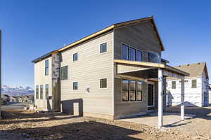 Rear view of house with a mountain view and a patio area