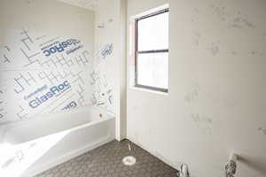 Bathroom featuring plenty of natural light, a bath, and tile patterned floors