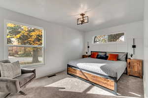 Bedroom #2. Main level. Carpeted bedroom with a notable chandelier