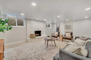 Carpeted living room featuring a stone fireplace