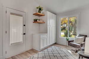 Sitting room with lofted ceiling and light wood-type flooring