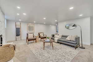 Living room featuring light carpet and a fireplace