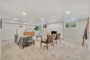 Carpeted living room with a stone fireplace