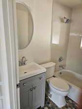 Full bathroom featuring tile patterned flooring, tiled shower / bath combo, toilet, and vanity