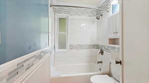 full Bath with Cast iron tub, tile surround, and plenty of light.