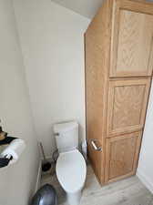 Bathroom with hardwood / wood-style flooring and toilet