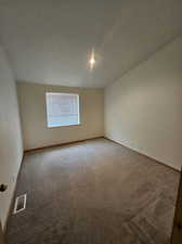 Spare room featuring carpet floors and a textured ceiling