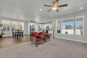 Interior space with ceiling fan with notable chandelier and light carpet