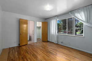 Unfurnished bedroom featuring a closet, hardwood / wood-style flooring, and a spacious closet