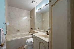 Full bathroom with shower / garden bath combination, toilet, and vanity