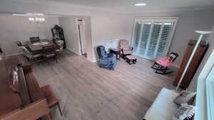 Interior space with light hardwood / wood-style floors and crown molding