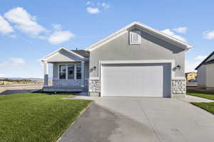 Front of home with a garage and a front lawn