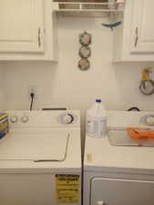 Laundry room featuring washer and dryer and cabinets