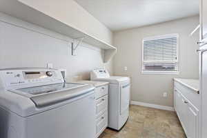 Huge laundry room has plenty of cabinets, countertop space, and hanging rod