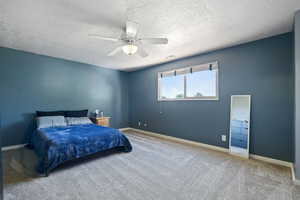 Carpeted bedroom featuring a textured ceiling and ceiling fan