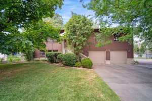 View of front of property with a garage and a front yard