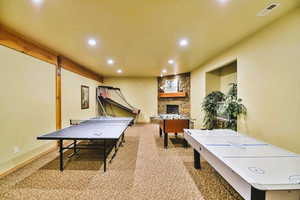 Gameroom featuring ping pong, air hockey, foosball, and a fireplace to enjoy