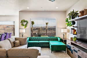 Carpeted living room featuring a textured ceiling