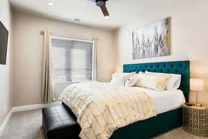 Carpeted bedroom featuring ceiling fan