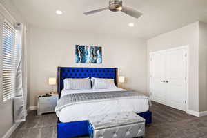 Bedroom featuring dark colored carpet, ceiling fan, and a closet