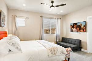 Carpeted bedroom featuring ceiling fan