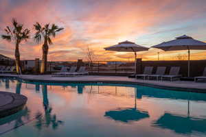 Pool at dusk featuring a patio