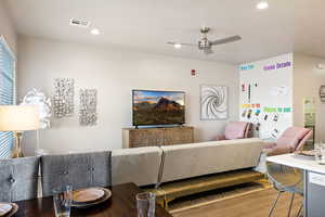 Living room featuring hardwood / wood-style flooring and ceiling fan