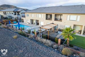 Back of property featuring a balcony, a patio, a fenced in pool, and central AC unit