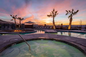 Pool at dusk featuring a patio