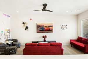 Living room featuring light carpet and ceiling fan