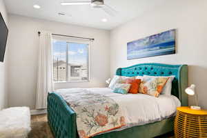 Bedroom featuring ceiling fan and dark carpet