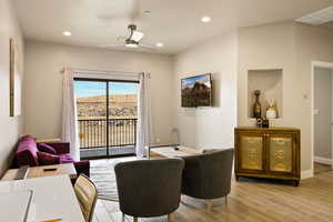 Living room with light hardwood / wood-style floors and ceiling fan