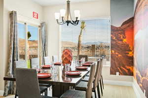 Dining room with light hardwood / wood-style floors and a chandelier