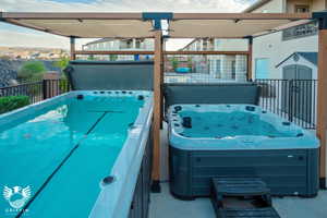 View of swimming pool with a hot tub