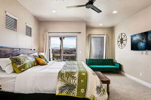 Carpeted bedroom featuring ceiling fan