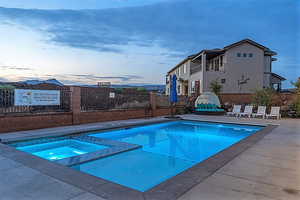 Pool at dusk with an in ground hot tub