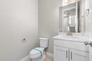 Bathroom with vanity, toilet, and hardwood / wood-style flooring