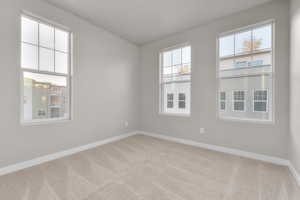 Unfurnished room featuring light carpet