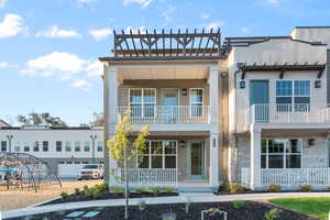 View of front of house featuring a porch, a balcony, and a garage